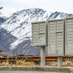 有隔间和数字的方形邮箱反对雪山和多云的天空邻里图片