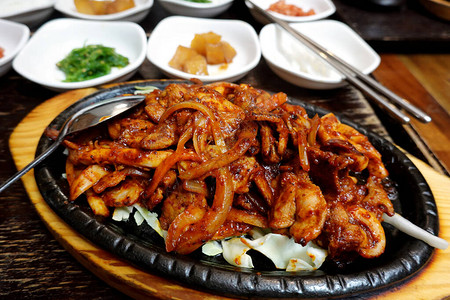 韩国铁板猪肉和鱿鱼配木桌上的配菜图片