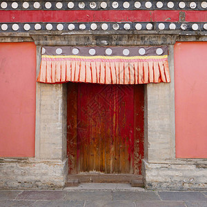 青海省西宁市湟中县藏传佛教寺院塔尔寺库姆寺的复古木门和墙壁背景