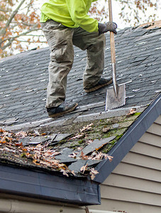 屋顶的工人使用一种特殊工具将旧闪光剂从图片