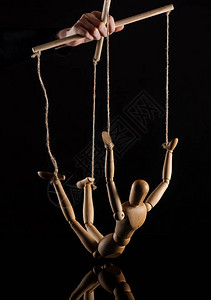 木偶人用黑色背景的绳索绑着木偶玩图片
