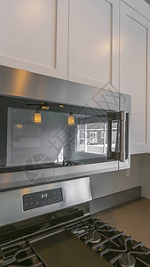 厨房墙壁上安装的微波和木制柜子紧贴图片