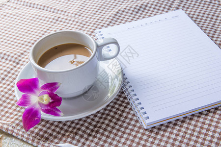 螺旋笔记本和一杯咖啡图片
