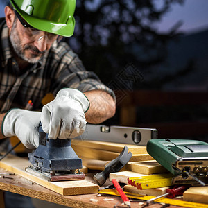 成年木匠工戴着防护皮手套背景图片