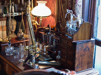 木制桌子玻璃管和台灯上的古董金色显微镜图片