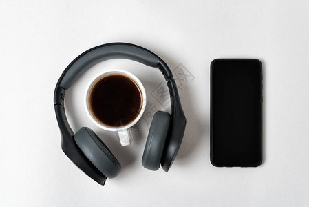 无线全尺寸耳机智能手机和白底咖啡杯背景图片