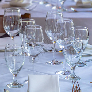 照片方形框架酒杯勺子用白布将碟子和餐巾放在桌子上棕色的木椅图片