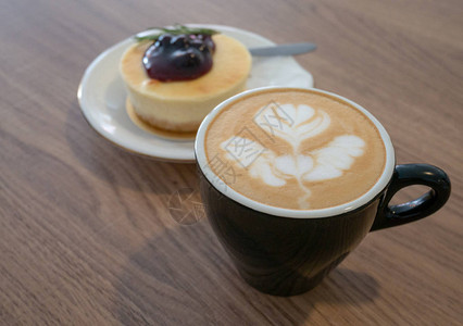 热咖啡在咖啡馆的木桌上用杯子和蓝莓芝图片