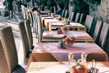 现代餐厅的餐桌布置咖啡厅室外露台上装饰的假日餐桌阳光明媚的夏天图片