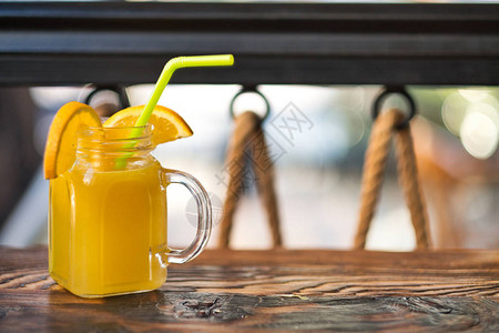 鲜榨有机橙汁特制的橙汁异国情调的酒精鸡尾酒装饰在木桌上木制的橙色和黄色图片