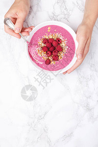 女人手握着大理石背景的草莓冰淇淋碗顶层视背景图片