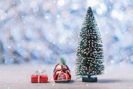 站立在圣诞树附近的一辆小玩具汽车的特写镜头概念图片
