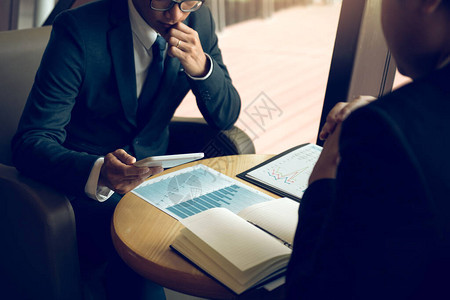 业务合作伙伴使用平板电脑在办公室绘制公司财务报表告和利润工图片