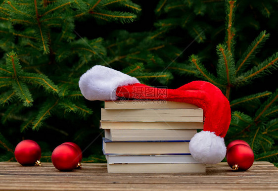 圣诞老人的帽子和木桌上的书还有背景上布图片