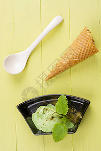 用勺子在木桌上放绿茶味冰淇淋平躺顶视图图片