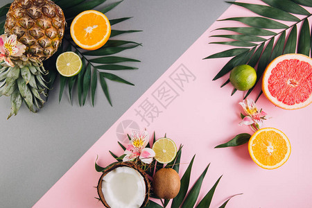夏季水果热带棕榈叶菠萝椰子葡萄果橙色和粉红色背景图片