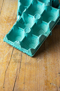 绿色木制桌子上空蓝色鸡蛋盒的空中视图图片
