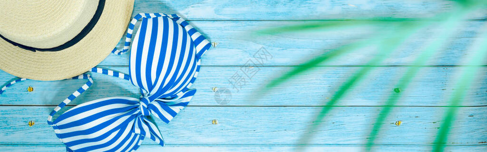 蓝木背景的泳衣和海滩饰物背景图片