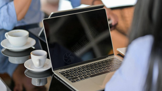 商人在使用电脑笔记本电脑时坐在简单的共同工作空间上被裁图片