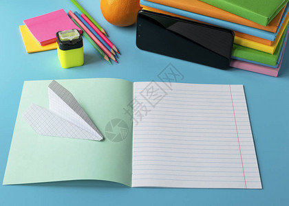 远程学习的概念一堆书笔记本铅笔手机在线学习背景图片