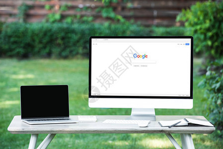 在户外餐桌上带有谷歌网站的空白屏幕计算机笔记本电脑选背景图片