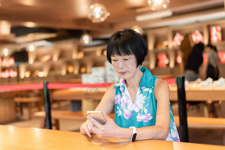 成熟的亚洲妇女在咖啡店谈手图片