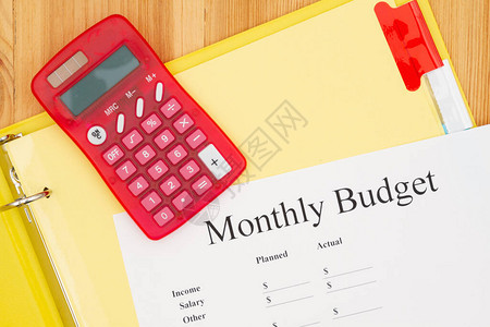 月度预算类型信息在木材桌上的黄纸盒中图片