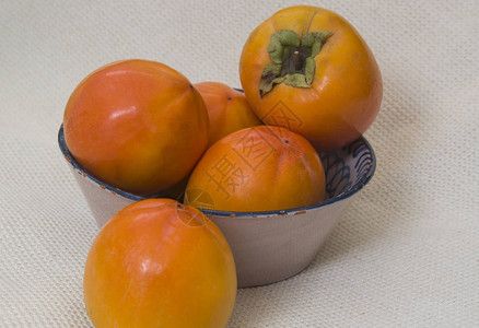 质朴盘子上的成熟柿子图片