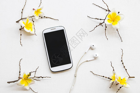 微信聊天群手机耳机和黄色花朵freangipani安排背景白背景
