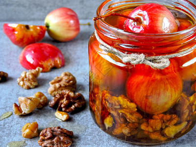 天堂苹果和核桃蜂蜜一罐蜂蜜配小苹果和坚果罐子里的营养蜂蜜混合物蜂蜜苹果和坚果的背景图片