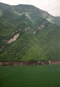 长江上的瞿塘峡灰色的云景沿着绿水后面的绿色覆盖的山坡下降一些米图片