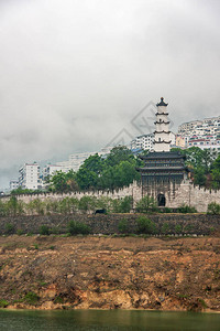 长江上的瞿塘峡门与塔的特写镜头到有宝塔的山上的历史堡垒遗址后面的山上飘着白雾部分绿色覆图片