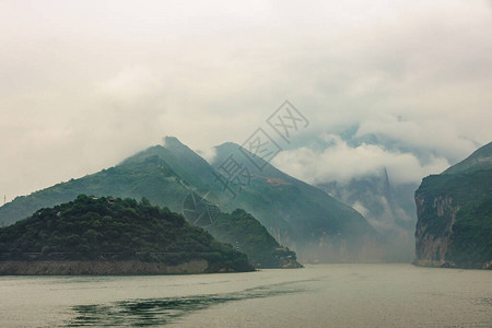 长江上的瞿塘峡从绿色山坡下降的朦胧cloudscape到峡谷的广阔视野景观图片