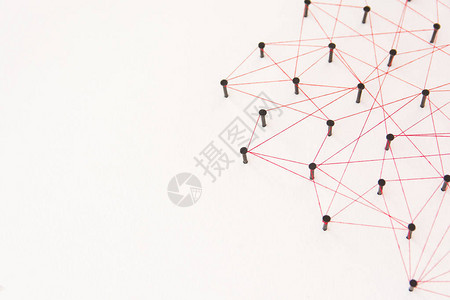 链接实体社交媒体通信网络两个网络之间的连接由黑钉和红线创建的具有复制空间的白纸背景图片