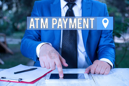 显示Atm付款的书写说明通过便携式电子设备进行无现金支付的商业概念商人在背景图片