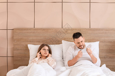 年轻妇女因为丈夫在卧室手机上玩游戏而睡不着觉图片