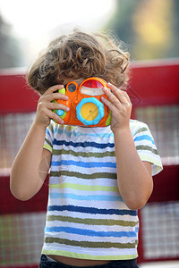小男孩握着玩具摄像机拍照片拿着图片