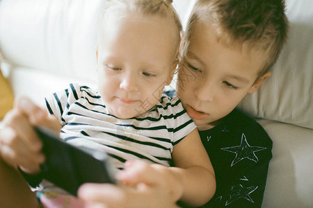 孩子们通过手机游戏度过家庭休闲时光大哥照顾小图片