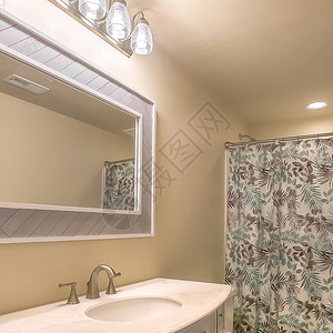 浴室内用木制地板和浅棕墙装有平方格和虚荣的厕所图片