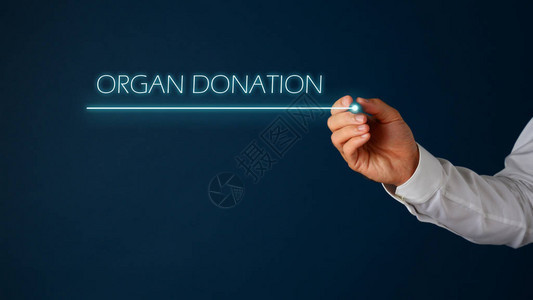 一位医生的手写着有机体捐赠标志上面有深情的笔蓝色背景图片