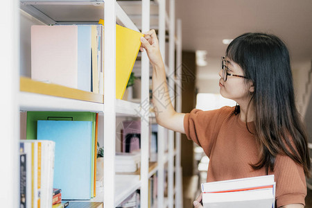 年轻的青少年在书架上订购学生在书店挑选文学作品进行教育检查信图片