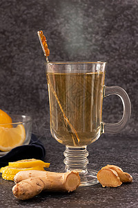 深色背景中的一杯热气腾的生姜和柠檬茶图片