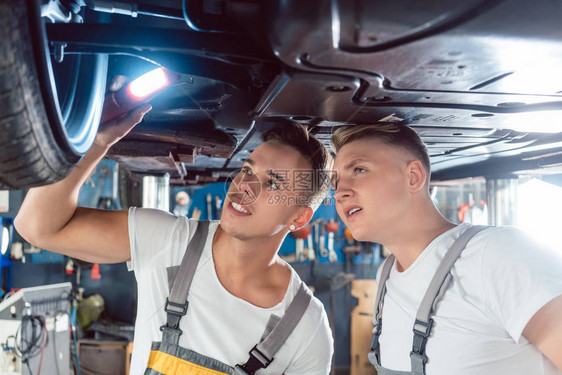两名熟练的汽车机械技工在现代汽车修理厂工作时图片