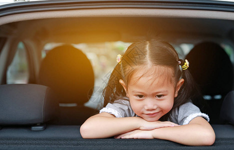 亚裔小孩坐在车的后门小图片