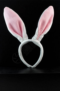 穿黑色背景的粉红色和白色复活节装扮兔背景图片