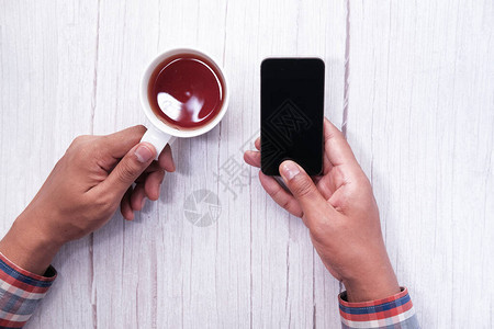 手拿咖啡杯用智能手机图片