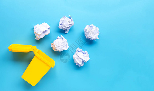 黄色垃圾箱蓝色背景上有白色折叠图片