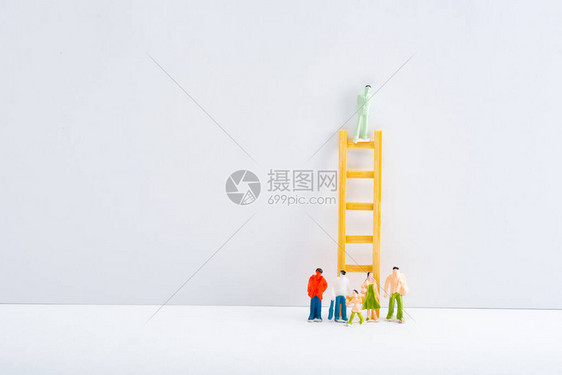 灰色背景的白色表面玩具在梯子附近的人物形象图片