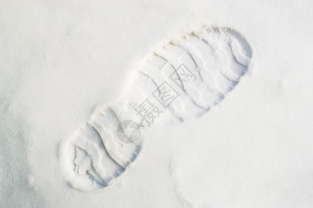 新鲜清脆的白雪中对角线构图中的单个人类脚印图片