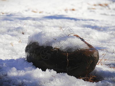 雪覆盖地面和一块大石头图片